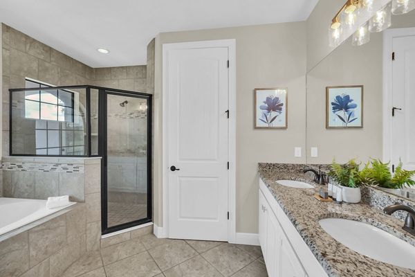 Master suite bathroom with large walk in shower, garden tub, and dual vanity