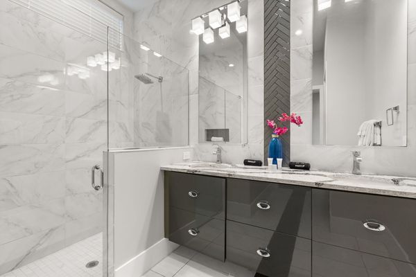 The ensuite bathroom has a large walk-in glass shower and double sinks