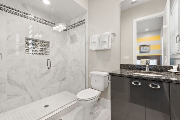 The ensuite bathroom perfectly matches the bedroom with pops of grey and yellow