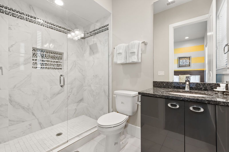 The ensuite bathroom perfectly matches the bedroom with pops of grey and yellow