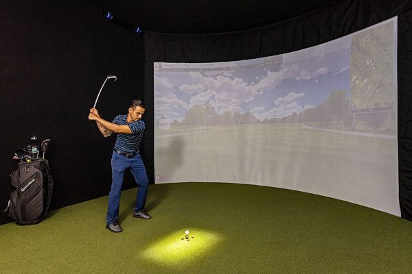 This High-Tech Sports Simulator Room features a SwingTrack Elite simulator with 87 PGA Golf Courses and 13 Sports Games