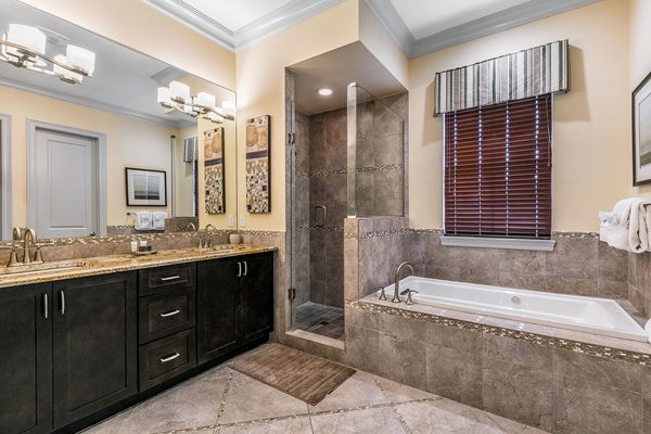 The en-suite bathroom has glass door walk-in shower, tub, and dual vanity