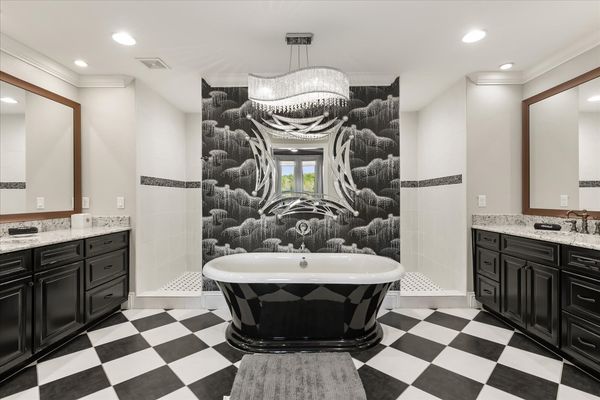 This ensuite bathroom features a garden tub, walk in shower and two sinks