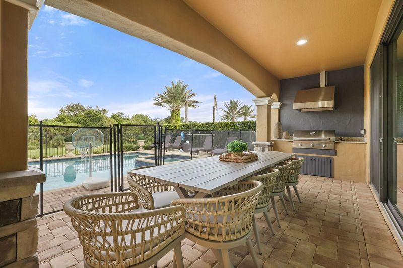 The home features a summer kitchen and outdoor dining table to enjoy a meal al fresco.