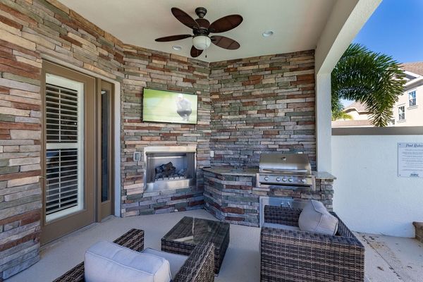 Hang out underneath the covered lanai with a summer kitchen, outdoor TV, and plush patio furniture (Disclaimer: Fireplace(s) not allowed for guest use, homeowner use only.)