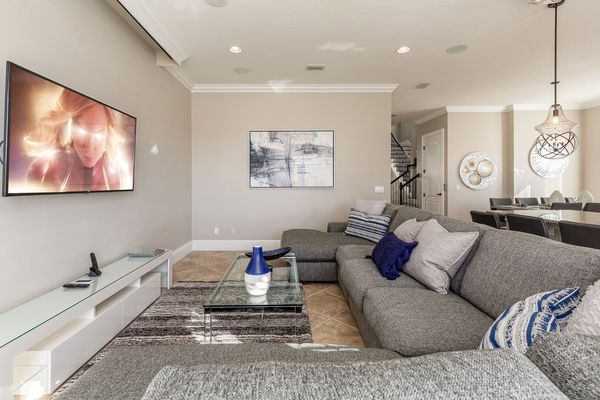 Lounge on plush couches in the living room while watching a favorite show on the 65-inch 4K SMART TV