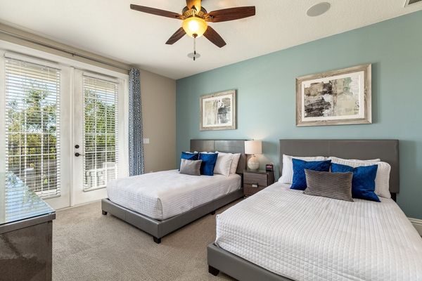 This relaxing bedroom features two Full beds and balcony access