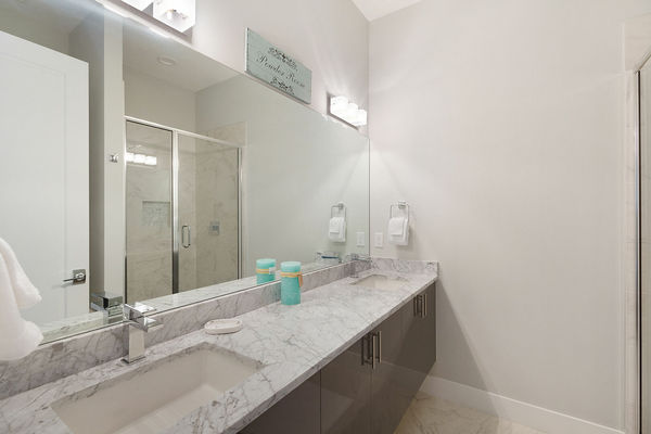 Sleek ensuite bathroom with a dual vanity and walk in shower