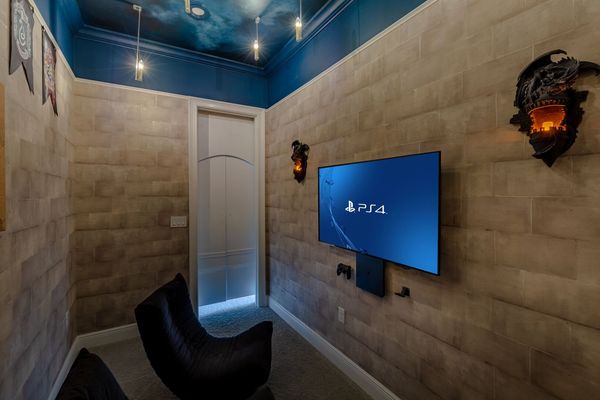 Inside is a large TV, Playstation 4  and 3 gaming chairs
