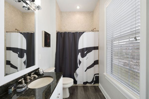 The ensuite bathroom has a shower/tub combination