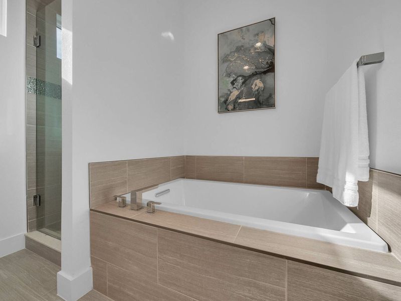 The ensuite bathroom has a large garden tub
