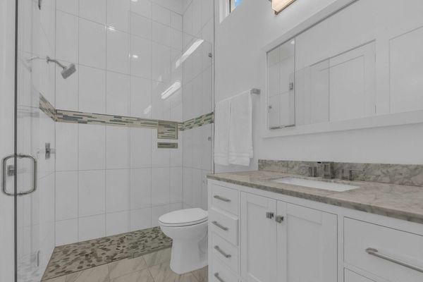 The bathroom has a tub/shower combination and a beautiful marble counter top