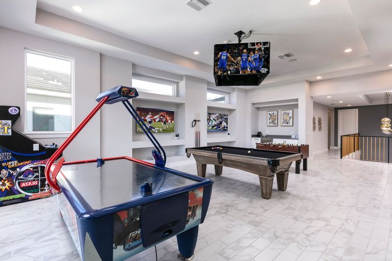 The loft is surrounded by 8 SMART TVs and a central jumbotron