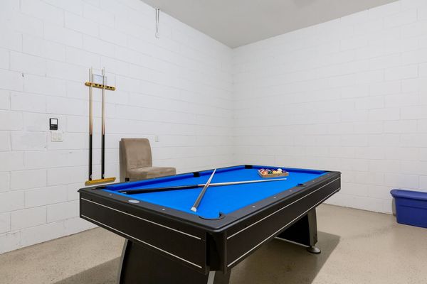 The garage has been converted into a game room with a pool table and comfortable seating