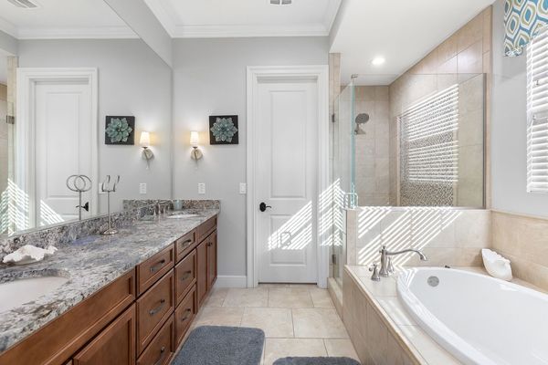 The en-suite bathroom features a glass shower and soaking tub