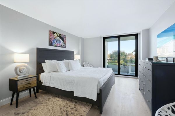 Bedroom 1 with one king bed, one queen bed, balcony access, attached bathroom, and 55-inch Smart TV