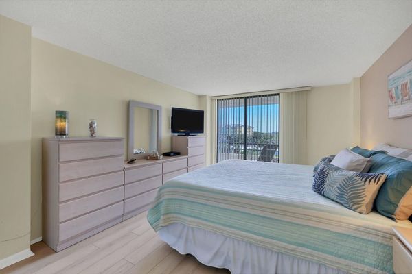 Primary bedroom with king bed ensuite, balcony access, 42-inch TV, crib, cell phone docking stations