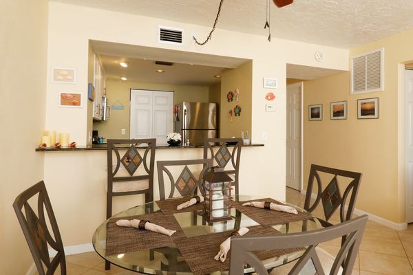 Dining room with seating for 4 at the table and additional seating for two at the breakfast bar