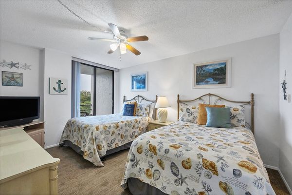 Guest Bedroom Features 2 Double Beds, Balcony Acces, Attached Bathroom, and 32-inch TV