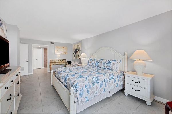 Primary bedroom with king bed, desk, en suite, balcony access, and 43-inch Smart TV