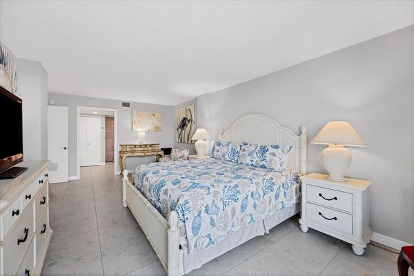 Primary bedroom with king bed, desk, en suite, balcony access, and 43-inch Smart TV