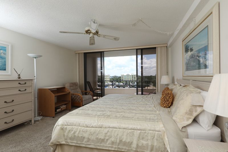 Primary Bedroom with king bed, 50" TV, attached bathroom and balcony access