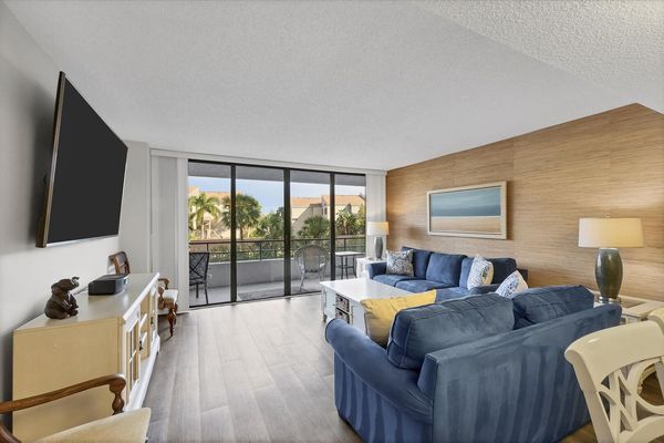 Living Room with lots of comfy seating, 75-inch Smart TV and balcony access