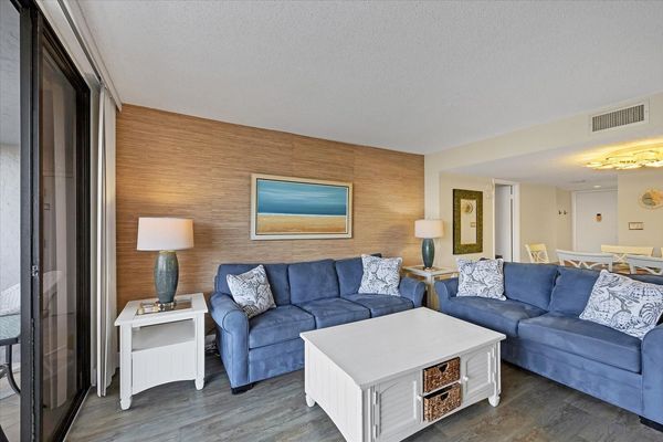 Living Room with lots of comfy seating, 75-inch Smart TV and balcony access