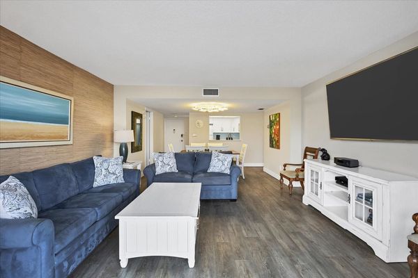 Living Room with lots of comfy seating, 75-inch Smart TV and balcony access