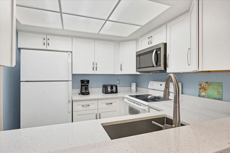 Bright, fully-equipped kitchen overlooking dining room / living room