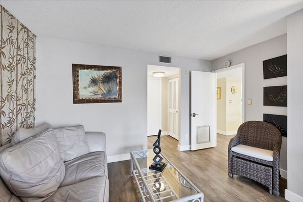 Primary bedroom with king bed, 55-inch Smart TV. sitting area, attached bathroom and balcony access
