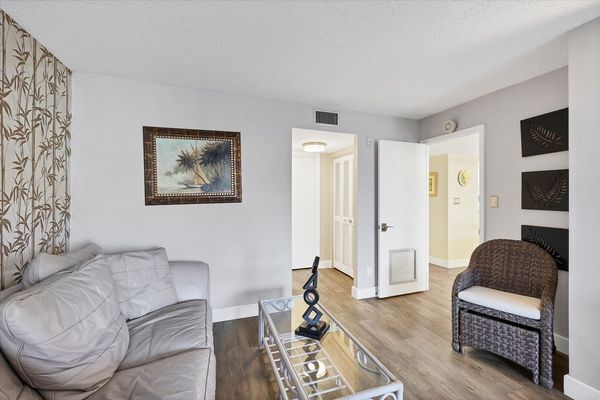 Primary bedroom with king bed, 55-inch Smart TV. sitting area, attached bathroom and balcony access