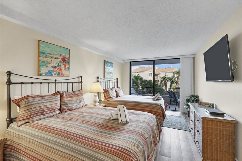 Guest bedroom with 2 queen beds, 55-inch Smart TV and balcony access