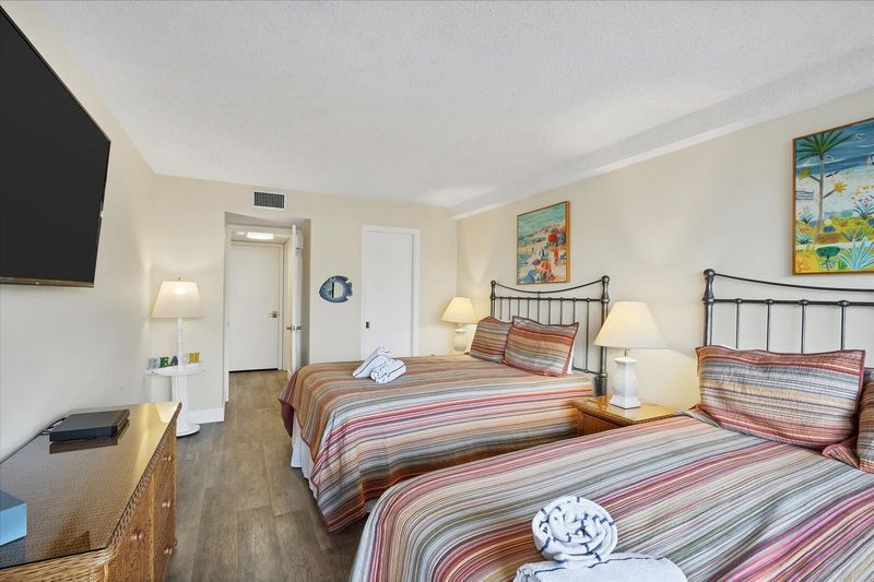 Guest bedroom with 2 queen beds, 55-inch Smart TV and balcony access