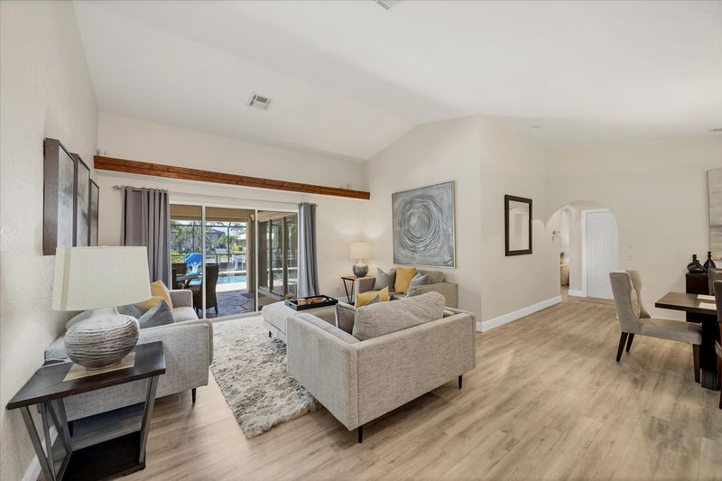 Formal living room overlooking the sparkling pool and canal beyond