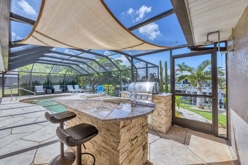 Lanai BBQ grill and bar seating. Pool size: 27' x 14' 5'