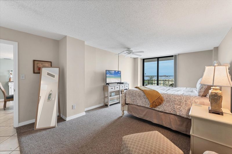 Primary bedroom with attached bathroom and balcony access