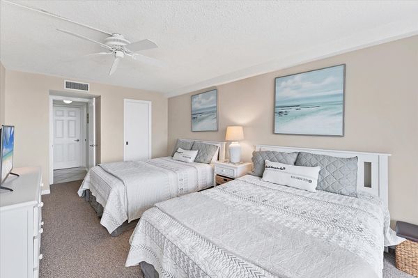 Guest bedroom with two queen beds and balcony access