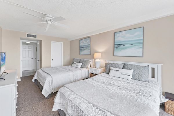 Guest bedroom with two queen beds and balcony access