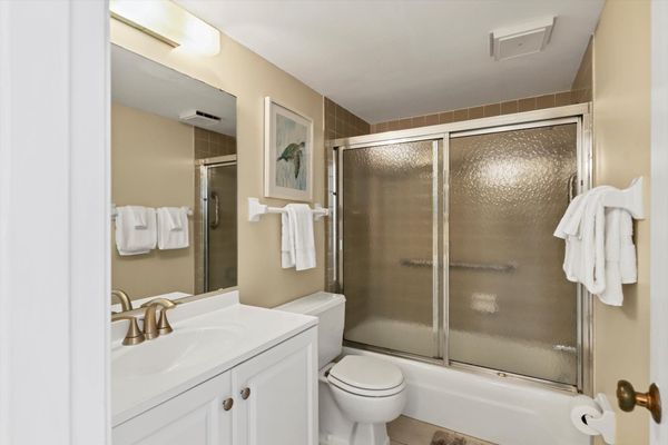 Bedroom 1's attached bathroom with shower/tub combo and two vanities