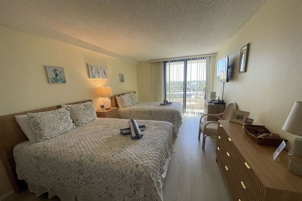 Guest bedroom with 2 queen beds, balcony access, 32-inch TV and Xbox