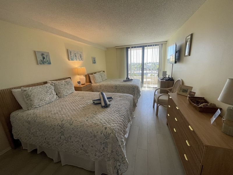 Guest bedroom with 2 queen beds, balcony access, 32-inch TV and Xbox