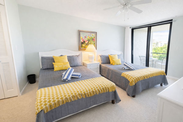 Bedroom 2 with two double beds, attached bathroom, and balcony access