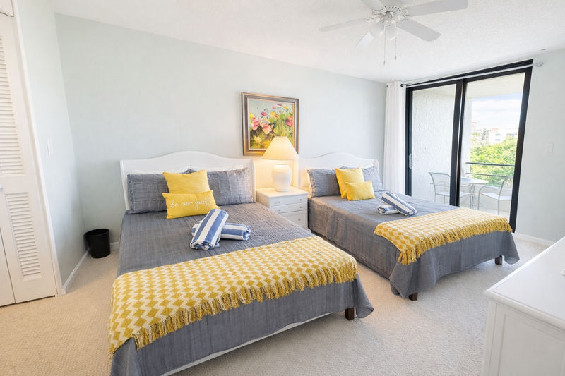 Bedroom 2 with two double beds, attached bathroom, and balcony access