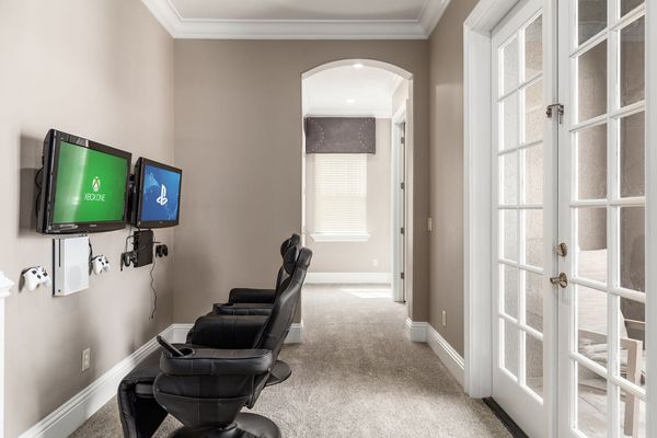 The upstairs hallway now includes a gaming area with comfortable chairs, equipped with Xbox One and a PS4.