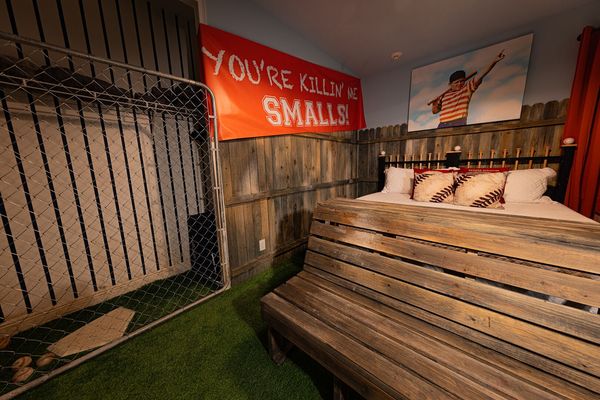 This Sandlot-themed bedroom features a king-sized bed and 55-inch 4K SMART TV, with a bathroom right outside the entrance to the bedroom.