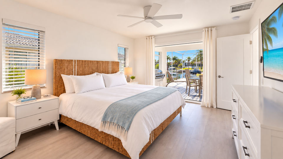 Primaary bedroom with king bed, attached bathroom, lanai acces, and 65-inch Smart TV