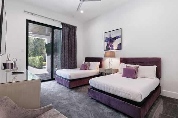 First-floor bedroom furnished with two full-size beds with access to the covered patio