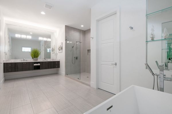 The ensuite bathroom has dual vanities, a walk-in shower, and a garden tub