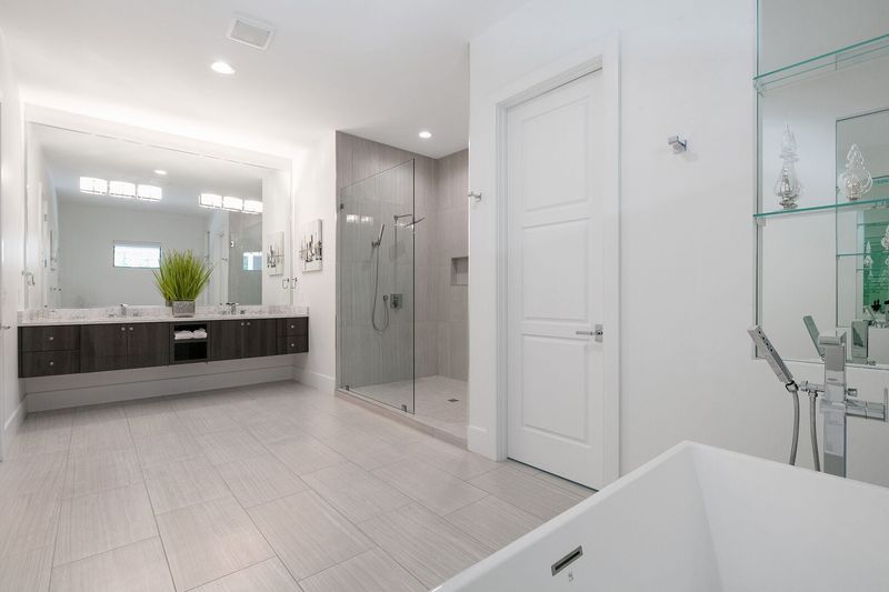 The ensuite bathroom has dual vanities, a walk-in shower, and a garden tub